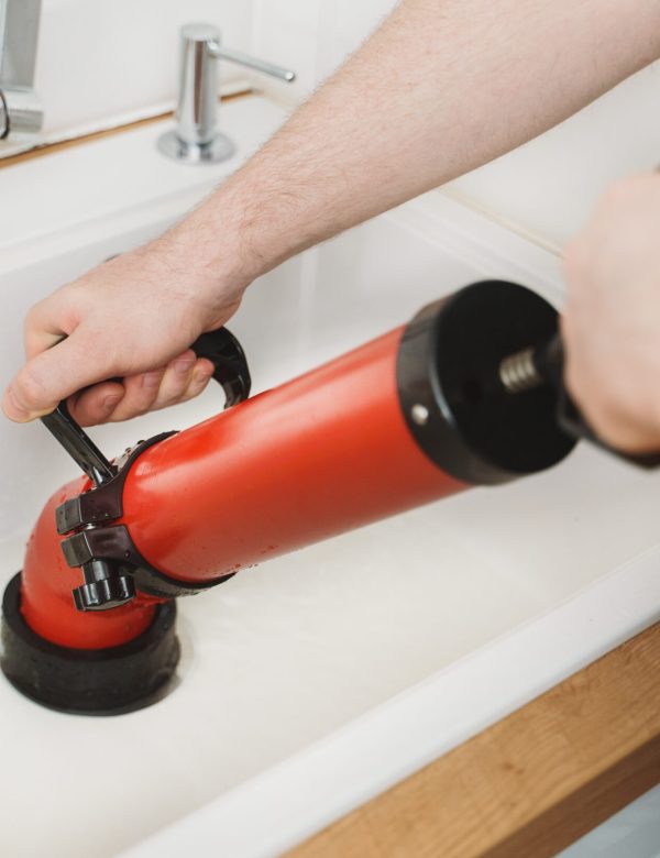 Plumber unclogging kitchen sink with professional force pump cleaner. Plumber unclogging kitchen sink with professional force pump cleaner.