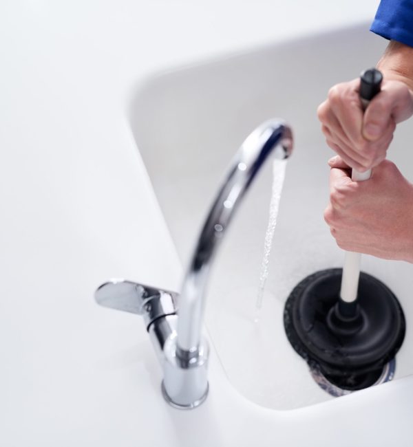 Keeping the drains clean. Cropped shot of a plumber. unblocking a drain with a plunger. Cropped shot of a plumber. unblocking a drain with a plunger.